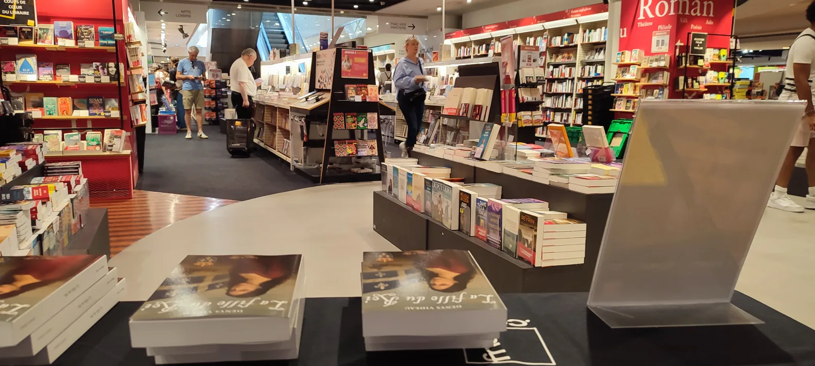 Vue depuis la table de dédicaces sur le rayon Livres du magasin et ses clients